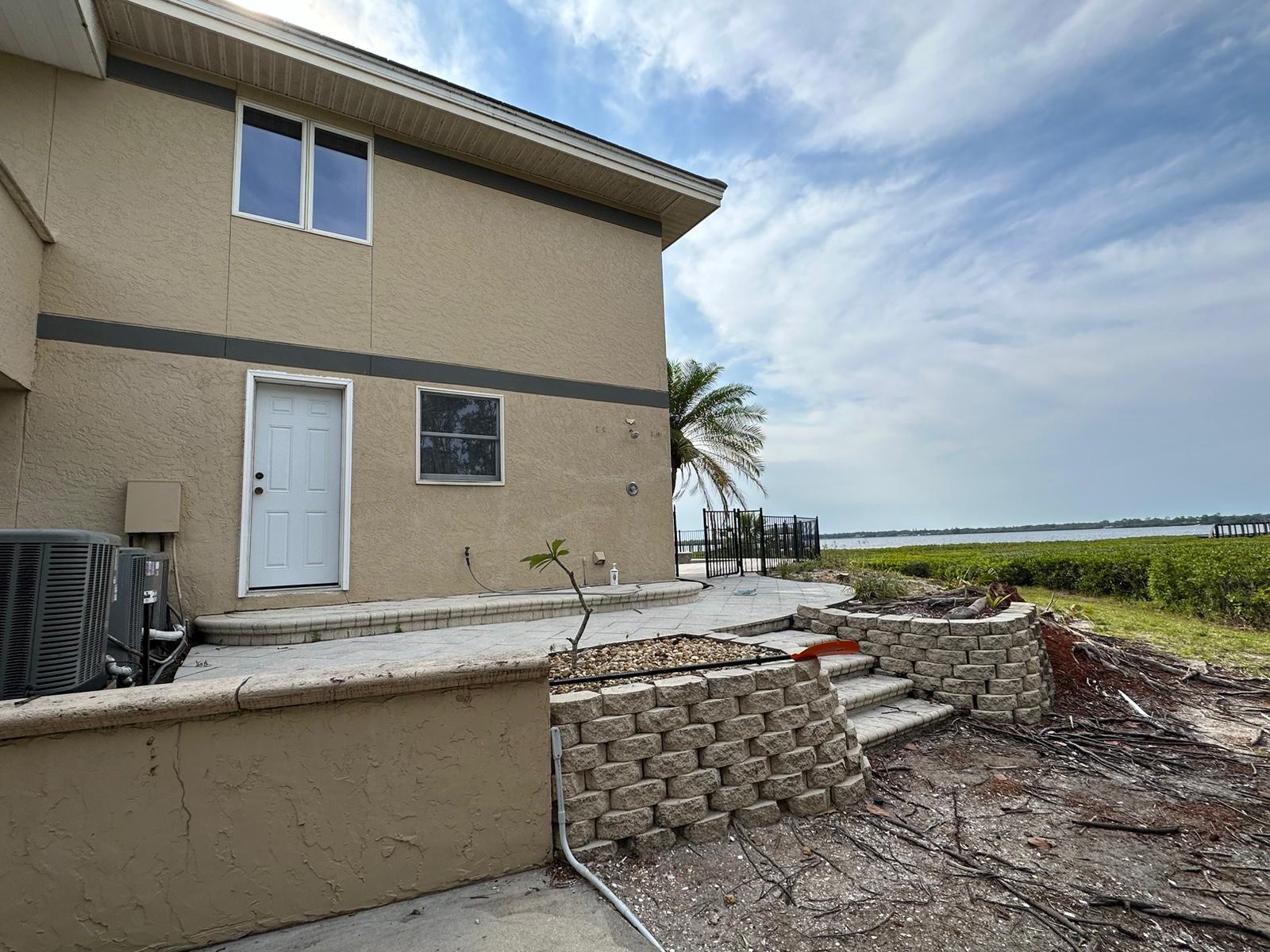 Rear paver patio and retaining wall by the water before renovation