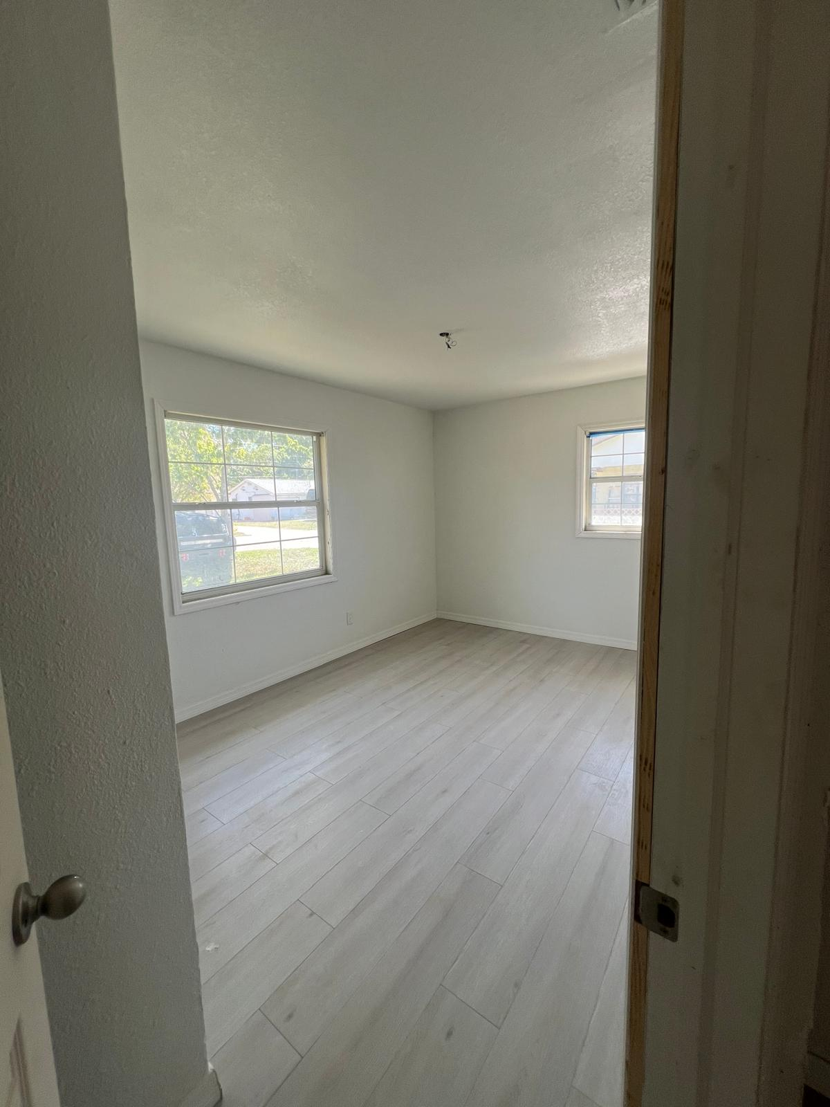 Newly installed light oak luxury vinyl plank flooring in a bright room