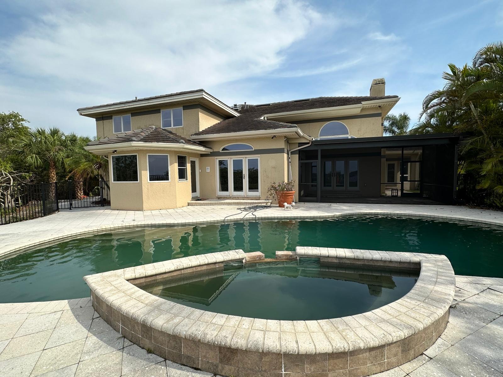 Tan stucco rear elevation with pool and spa before renovation