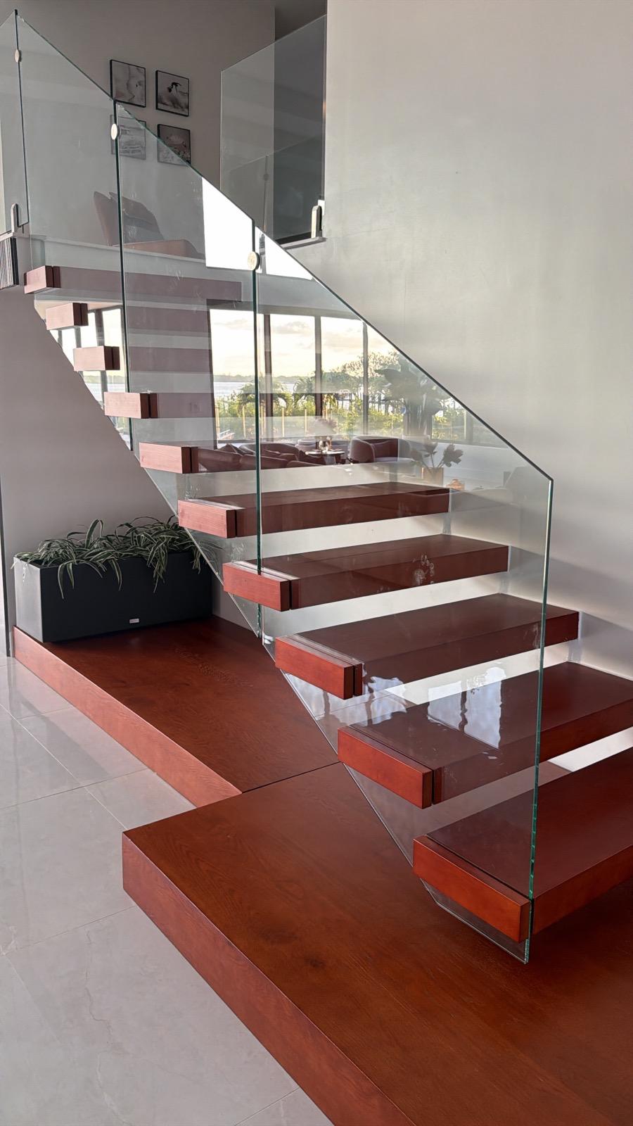 Floating wood tread staircase with frameless glass railing