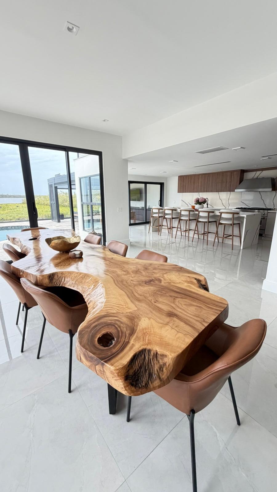 Open kitchen and dining area with live-edge wood table and polished porcelain floors