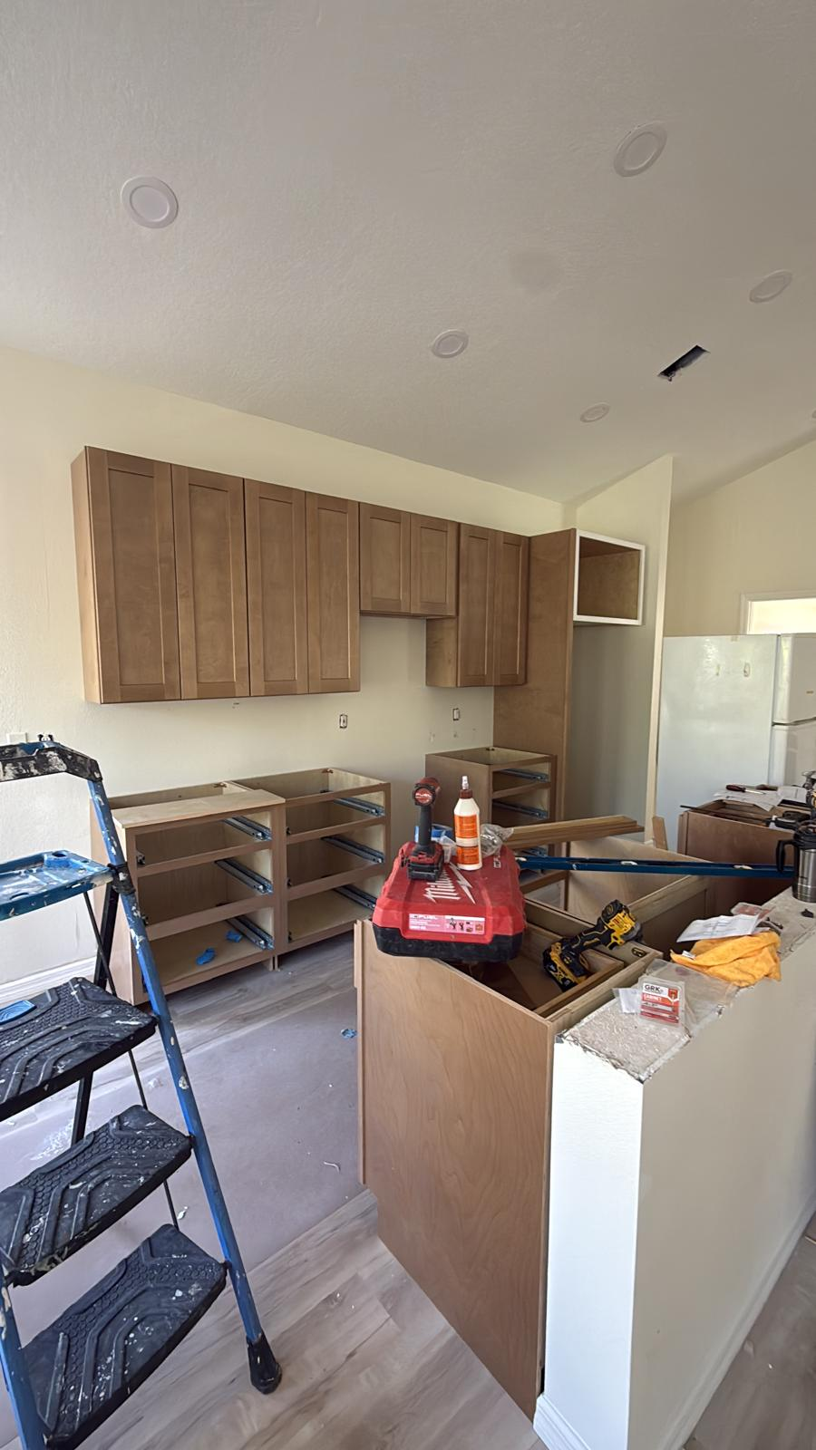 Shaker kitchen cabinets installed with base cabinet framing in progress