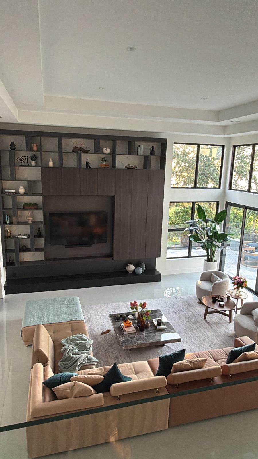 Living room with floor-to-ceiling dark media wall, marble shelving and floating hearth