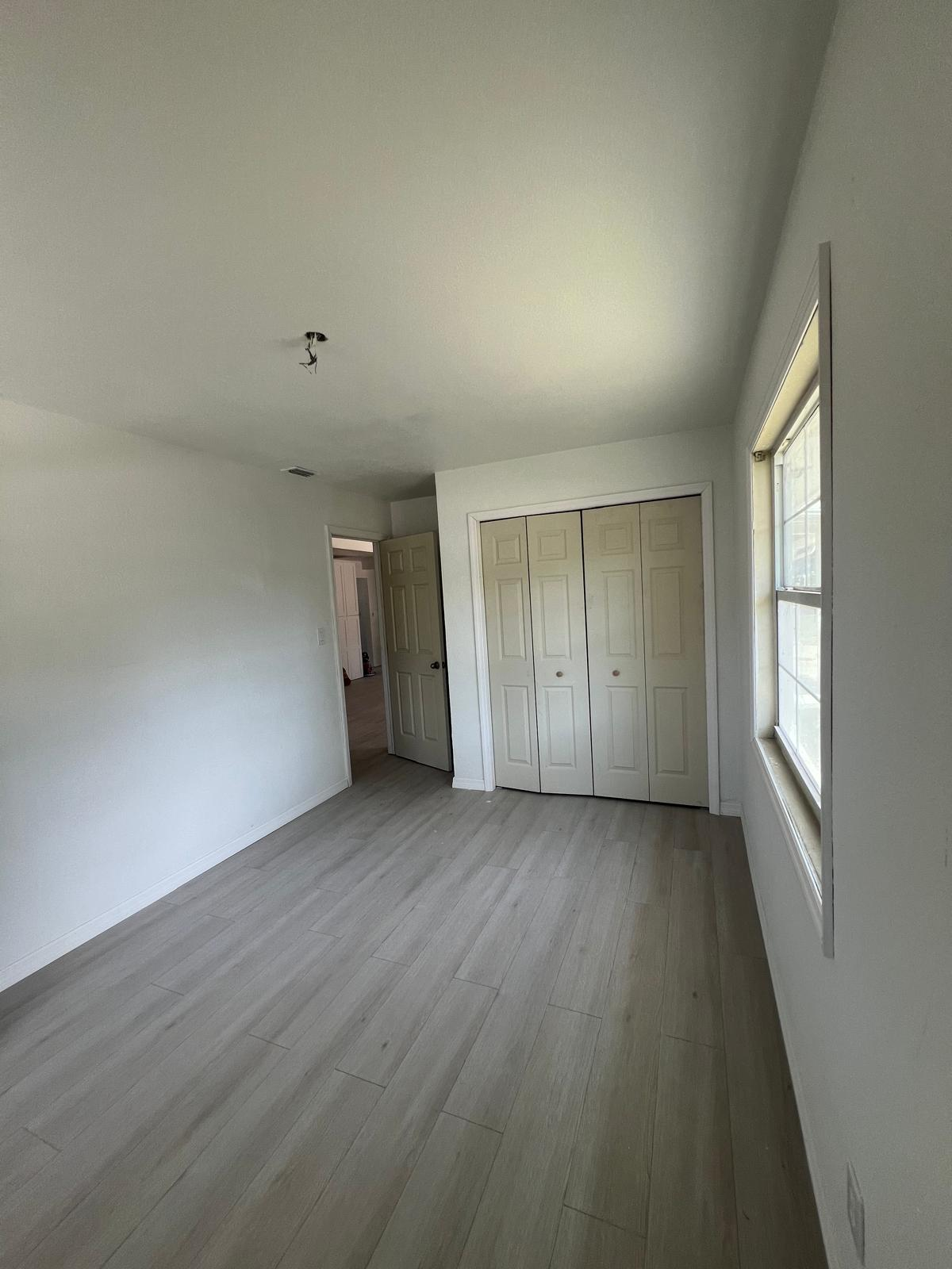 Bedroom with vinyl plank floor and freshly finished closet doors