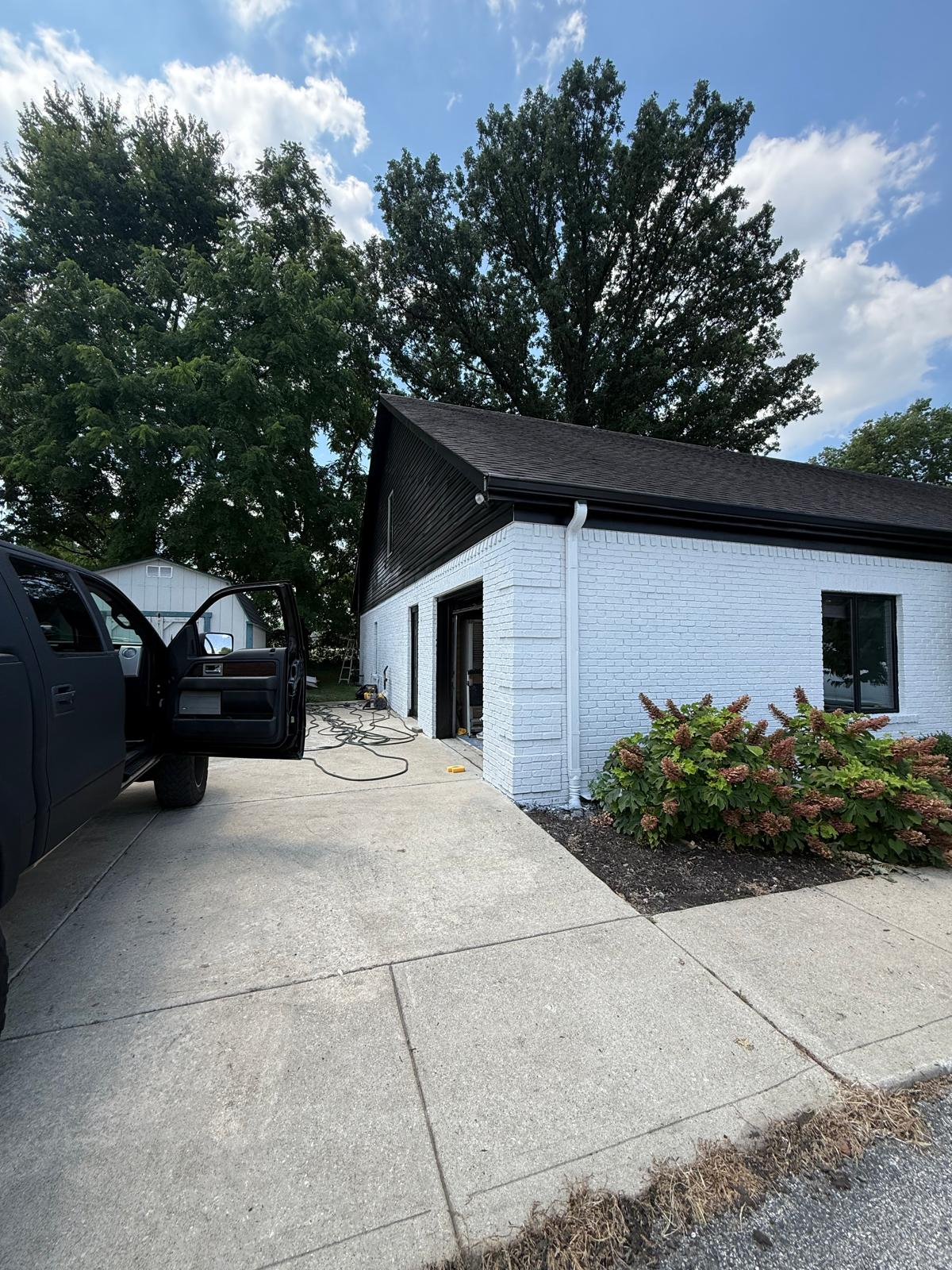 Freshly repainted white brick exterior with dark trim and crisp finish details
