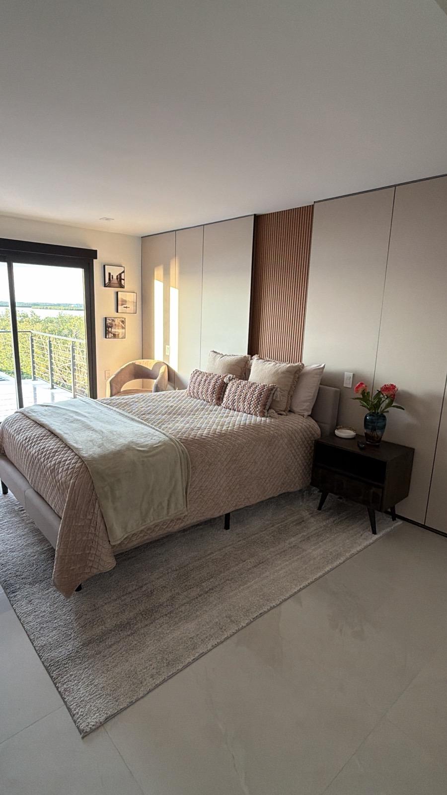 Master bedroom with full-wall built-in wardrobe and wood slat accent panel