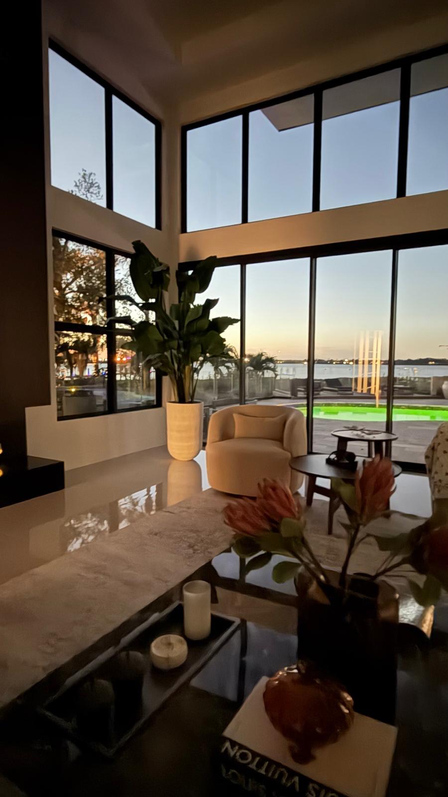 Corner lounge with stone counter, tall windows and sunset water view